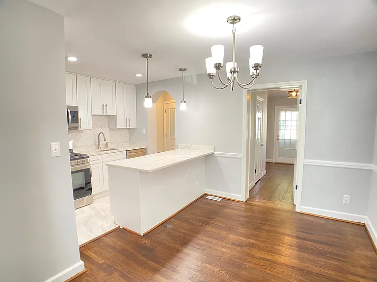 Kitchen and Dining Area, also showing Kitchen Island Bar area, ready for your stools. In the back, the main level 3rd bedroom and full bathroom.