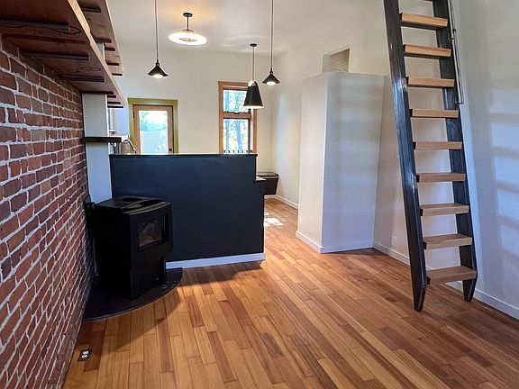 Main living area with fireplace looking towards kitchen and dining area