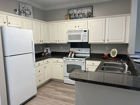 The kitchen includes freshly remodeled cabinets, new LVP flooring, stylish white appliances and a brand new garbage disposal.