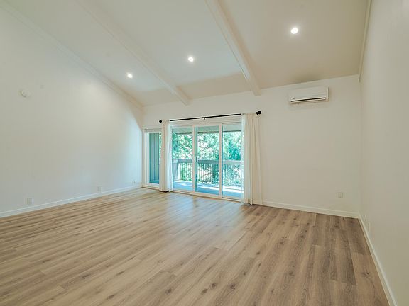 Extra large living room with cathedral ceilings, dimmable recessed lights. 

This view is from the front hallway looking into the living room out toward the long and expansive balcony that adds additional indoor/outdoor space, great for relaxation too!