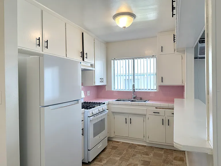 Kitchen with gas stove and refrigerator