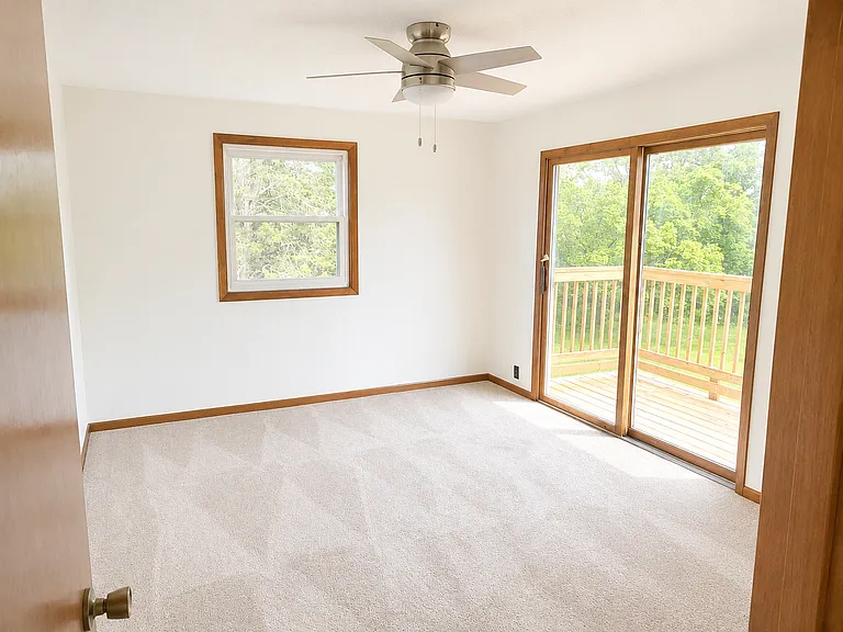Primary bedroom. Beautiful deck overlooking the back of the acrage.