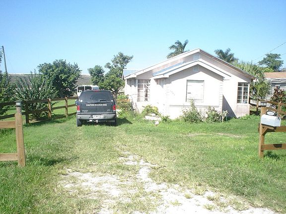 exterior front with ample parking inside fence