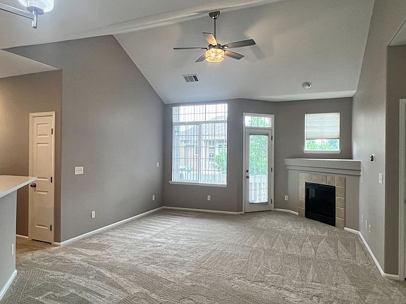 Living room with brand new carpet, new ceiling fan, new paint throughout and gas fireplace.