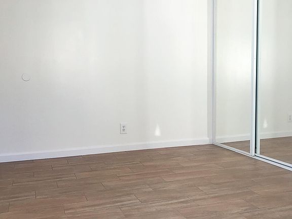 Bedroom with new ceramic flooring and ample closet space.