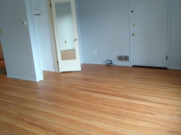 living room with refinished hardwood floors and coat closet