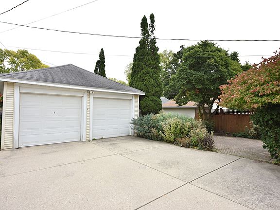 Shared garage, back patio area, and green space behind building.