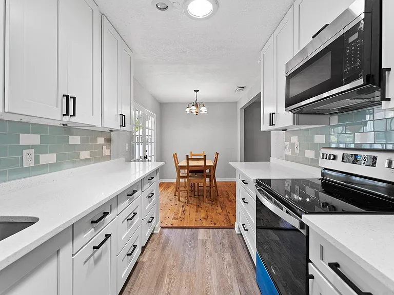 Galley kitchen with ample cabinet storage, generous counters, stainless appliances, and an adjoining eat-in dining nook.