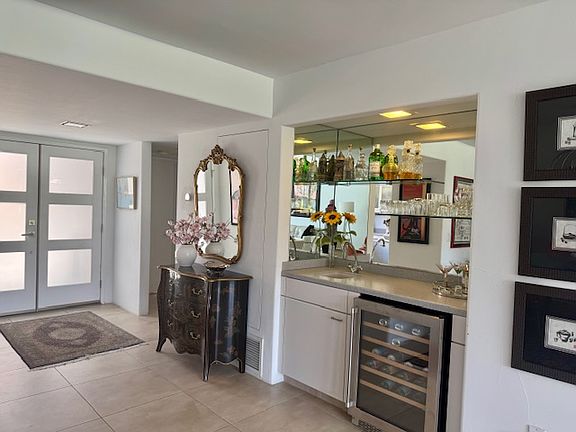 Looking toward front door and entrance to powder room and guest bedroom and bath.