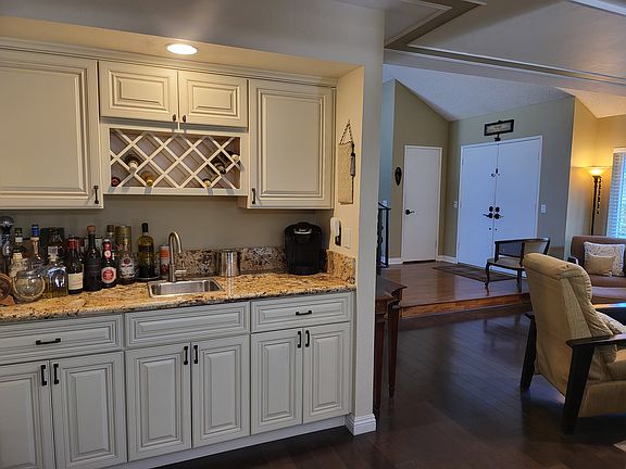View of wet bar area, across from the dining area. View of entry way and foyer area in background.