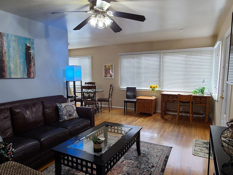 front room with 55" smart TV and desk in sunny corner