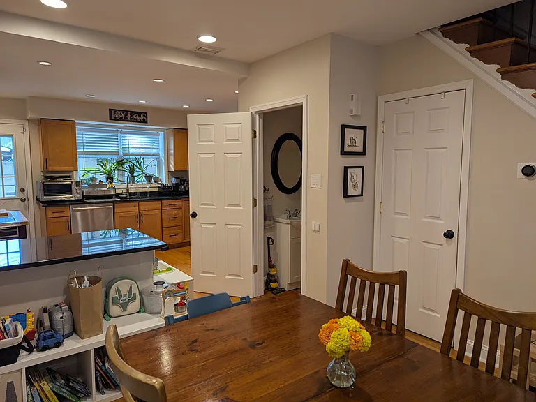 Dining and kitchen. Powder room door open and basement door closed.