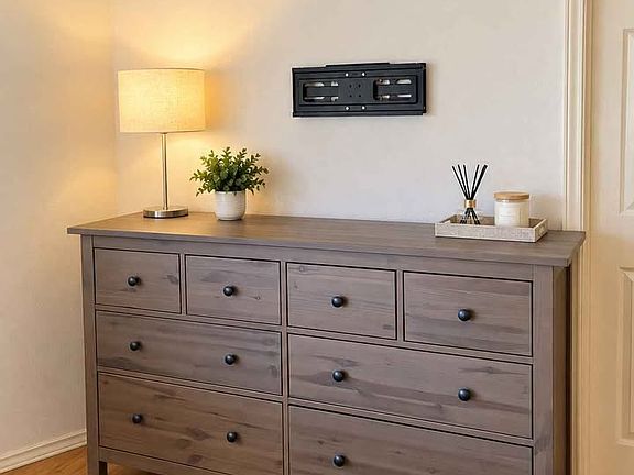 Roomy Ikea chest of drawers with a TV mount above it