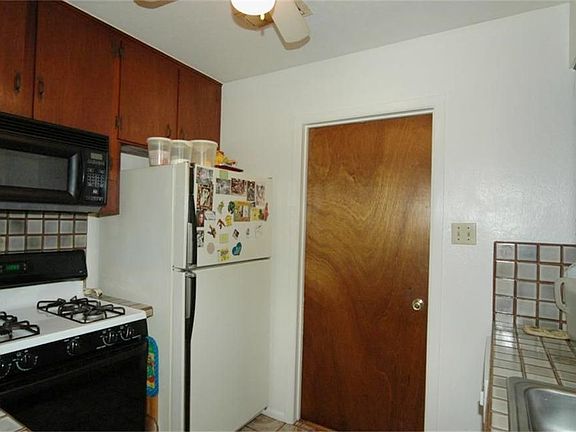   The kitchen features a gas range and includes your own fridge! The door leads to the utility room that has room for storage!