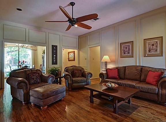 Spacious Living Room has Hardwood Flooring, Picture Frame Moulding & Custom Ceiling Fan!