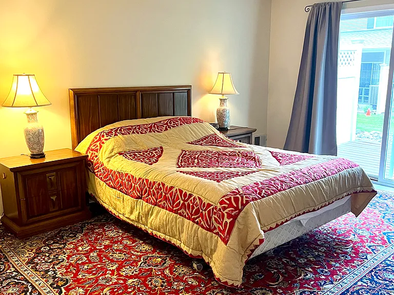 Large master with walk in closet, en suite full bath and glass slider that leads to deck