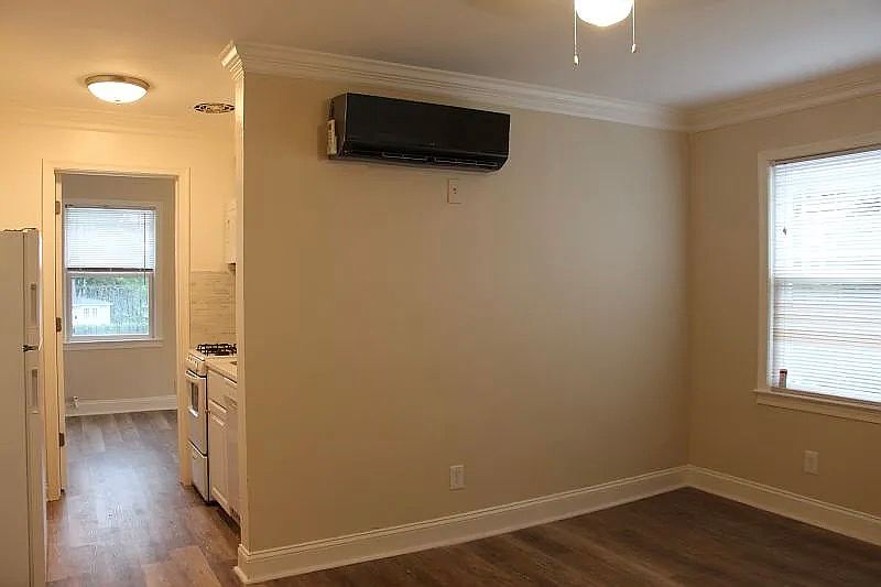 Living Area: view from the unit entrance door. Two windows, AC. Space for a couch, dining table, and work desk.