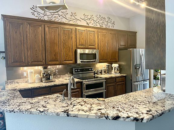 Kitchen with granite countertop and stainless steel appliances.