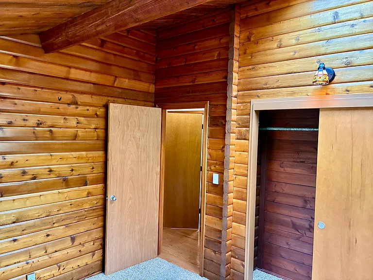 Bedroom One with natural wood log walls.