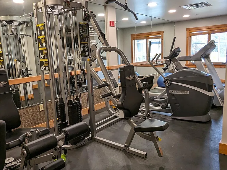 Fitness center includes a variety of weight and cardio equipment, a steam room, and mens' and womens' locker rooms that lead out to the pool and hot tub courtyard.