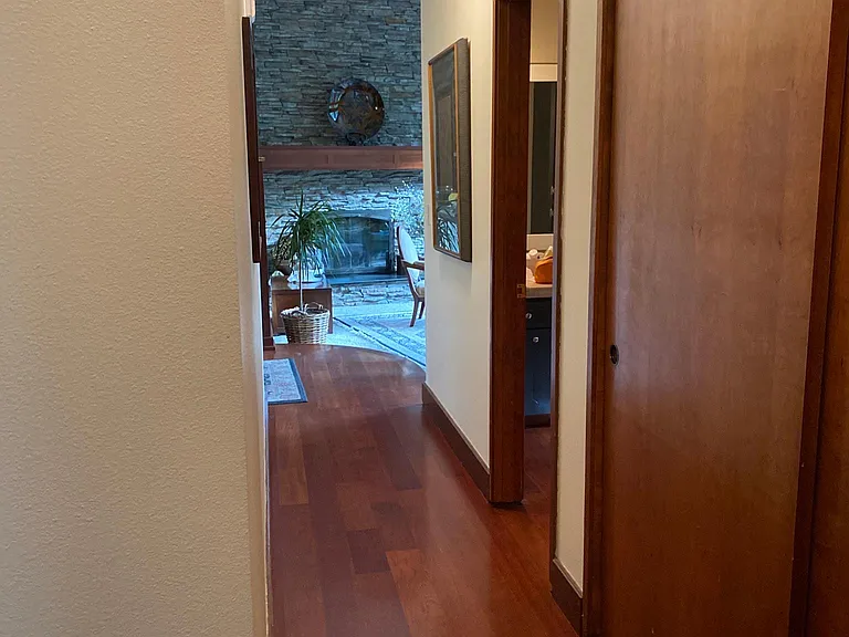 Hallway leading to living room. Pull down attic storage in hall.