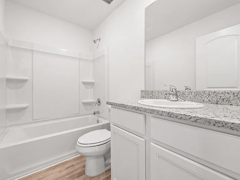 Additional bathroom with granite countertops.
