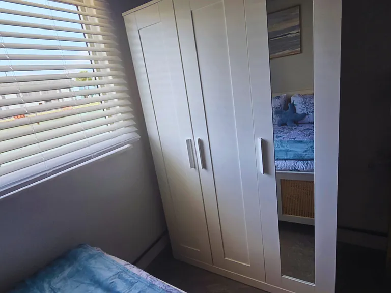 Large window with stylish blinds and a roomy closet for your belongings.