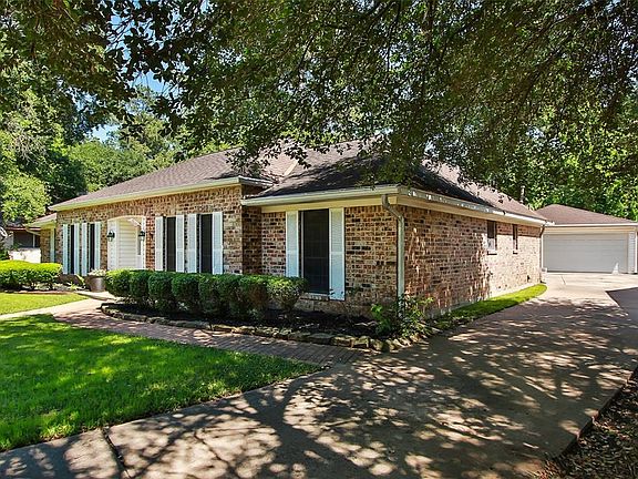 Paver walkway to driveway leading to detached garage.