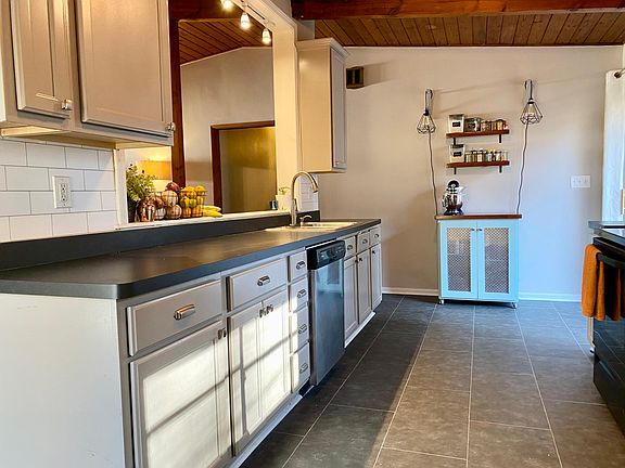 Kitchen with passthrough opening overlooking stairwell, living and dining room and hallway to bedrooms.