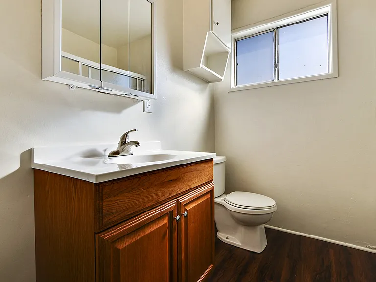 Bathroom with wood style single vanity cabinet, hardwood style flooring