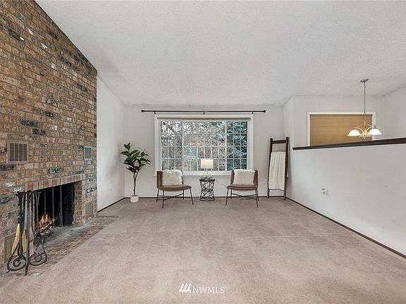 Living room with wood burning fireplace and large picture window. 