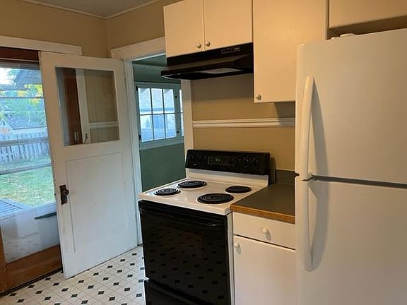 Kitchen with oven and refrigerator. Door out to the back deck and door to back porch.