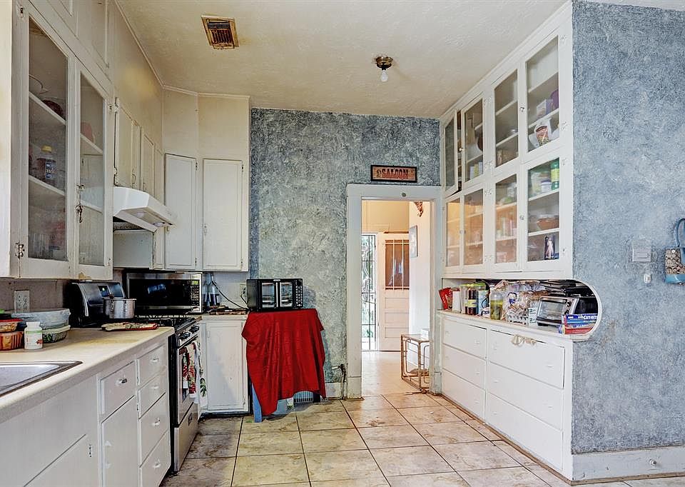 Kitchen with lots of built-ins and tile flooring . The house does need updating.