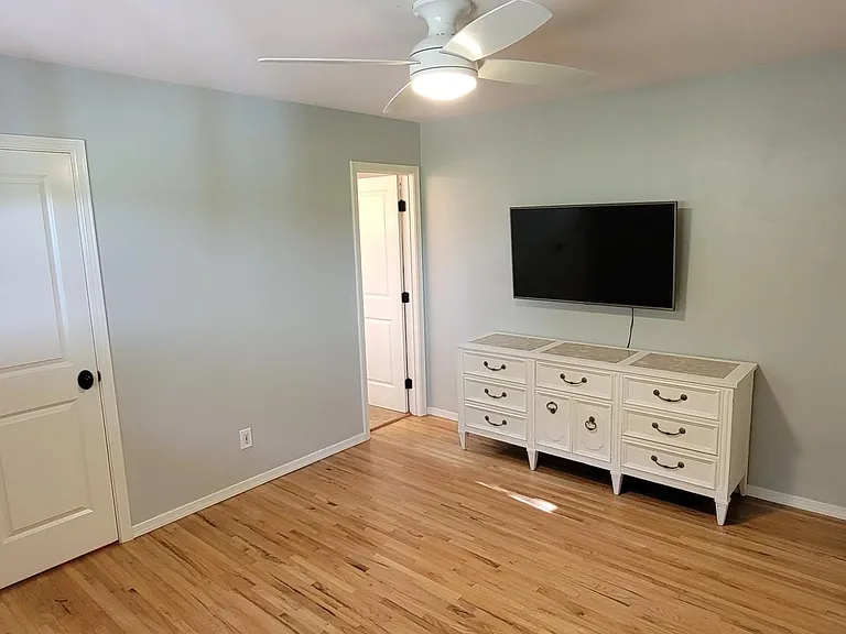 Master Bedroom with ceiling fan and shelving for storage