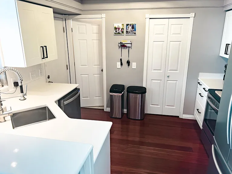 White soft close kitchen cabinets, updated hardware and stainless steel appliances.
