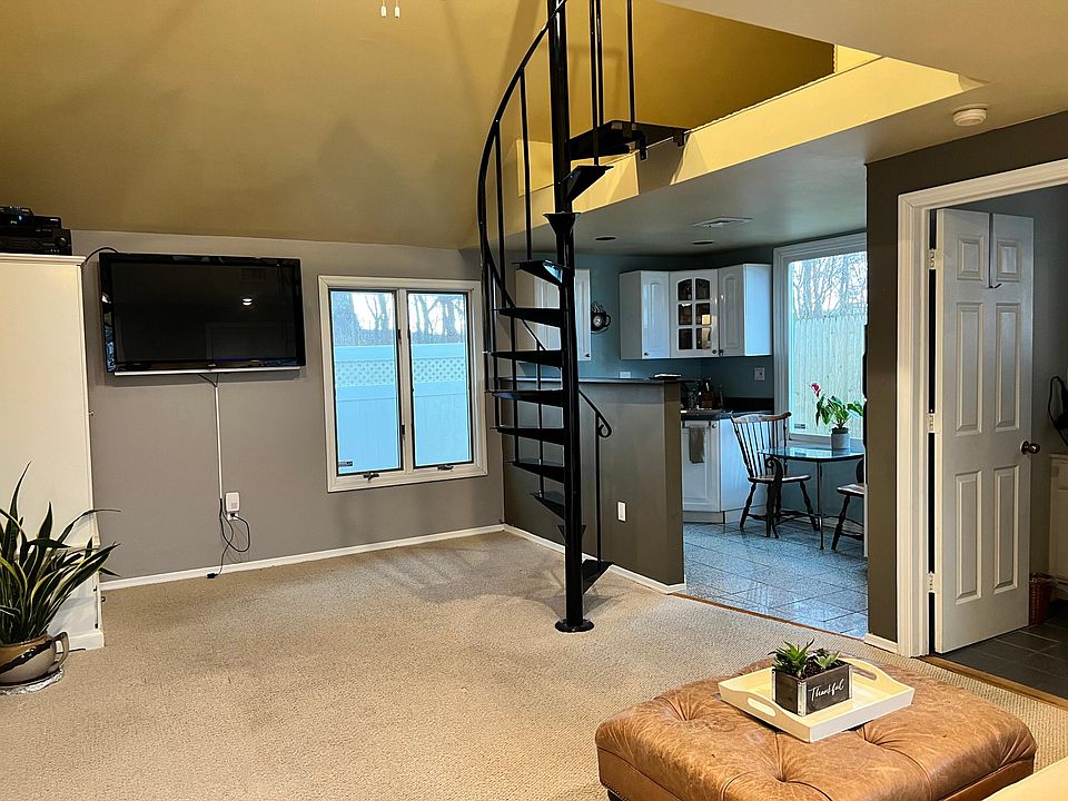 Living space with spiral staircase leading up to loft sleeping area.