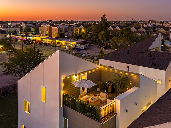 An aerial view of a house with a patio at dusk.