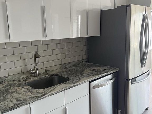 Renovated kitchen with subway tiles, custom cabinets and stainless steel appliances