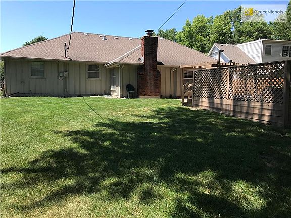 Generous fenced and shady back yard with deck and patio.