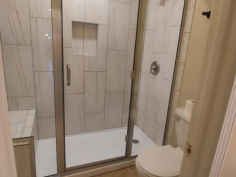 Glass shower with seat in master bath. Additional privacy door.