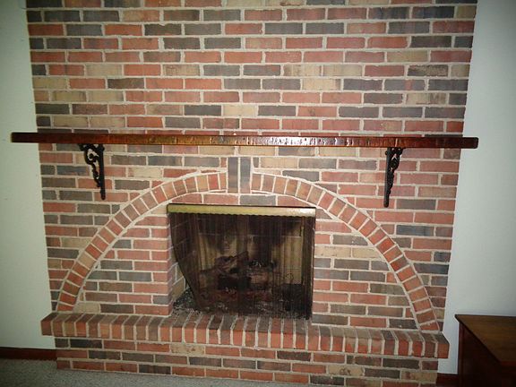 There is a brick fireplace with a gas starter