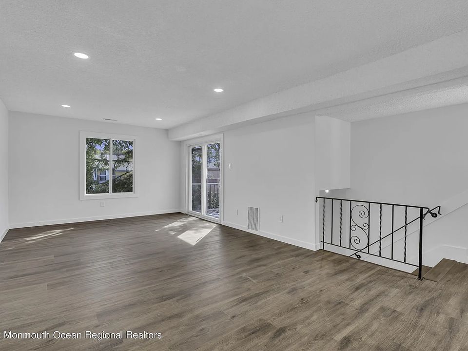 View of living room/balcony door/stairwell/coat closet from the dining area corner