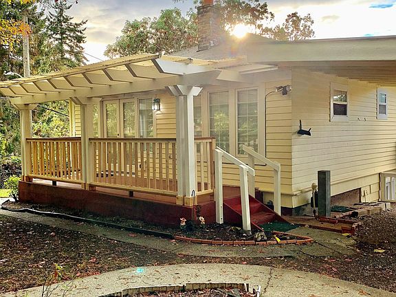 Front entry with covered porch adjacent to carport.