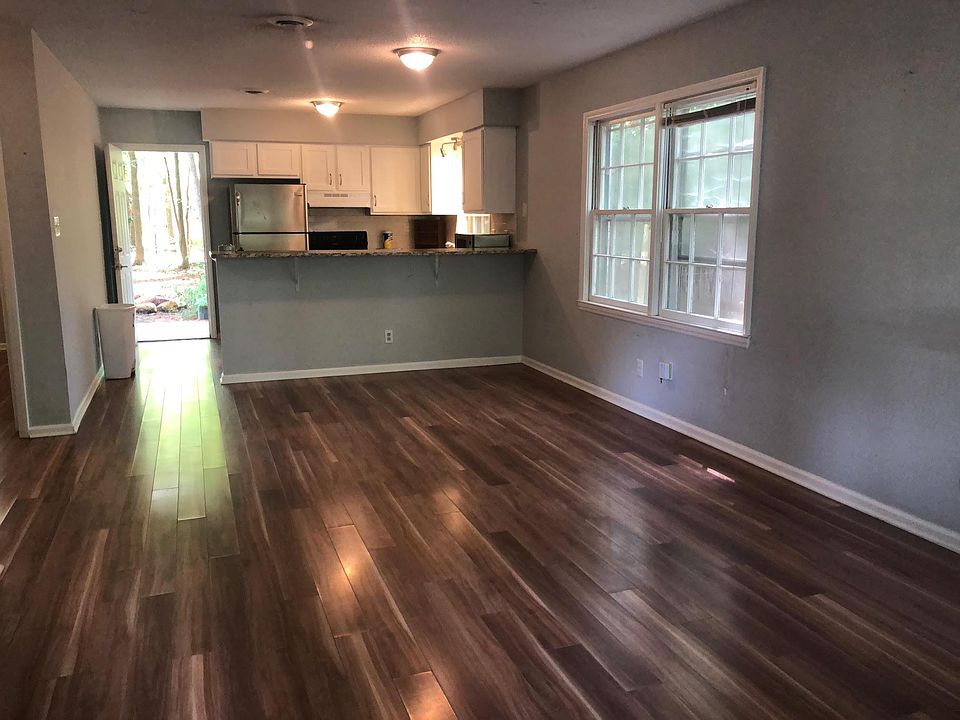 Side B, Living Room and Kitchen - open concept with bar/counter. All Appliances included; Refrigerator, Stove, Dishwasher, Clothes Washer and Dryer. Door by refrigerator leads to back patio, partially fenced yard and Carrboro deer path in the woodsy bac