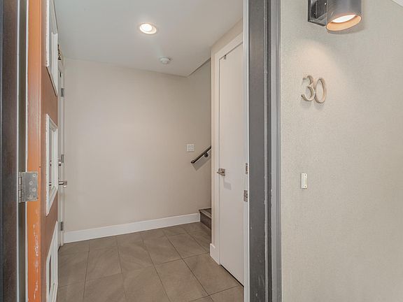 Front door entrance with storage closet to right and 2 car garage to left