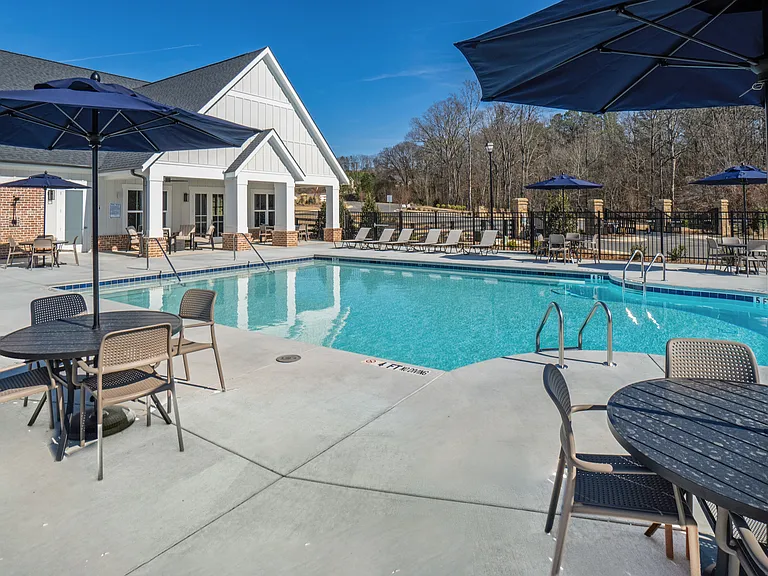 Pool off the backside of the Clubhouse that offers table seating with umbrellas.