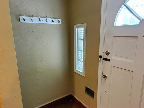Tiled front entry with coat hooks. More hooks on opposite wall. Room for table or dresser for keys/shoes/gloves etc.