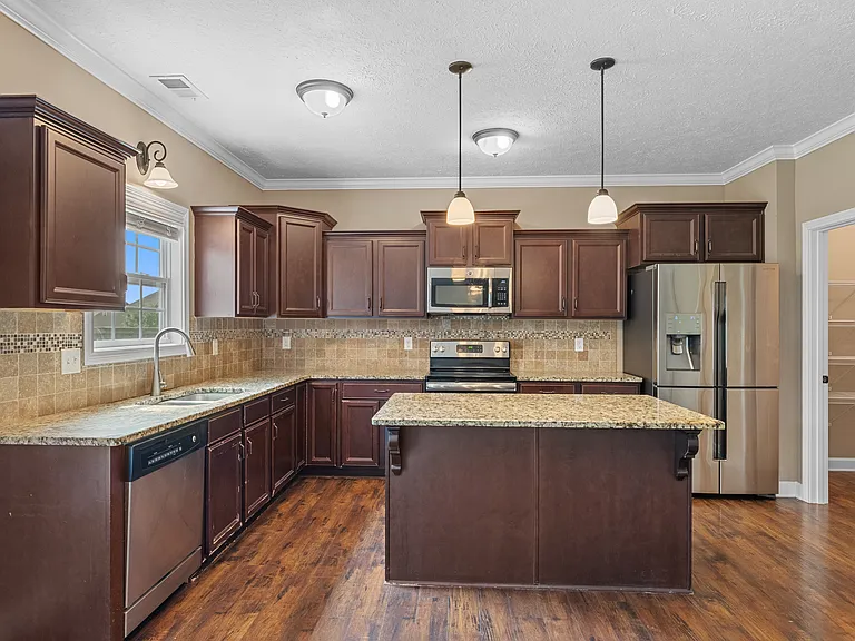 Kitchen has granite countertops, lots of cabinetry, and space to work