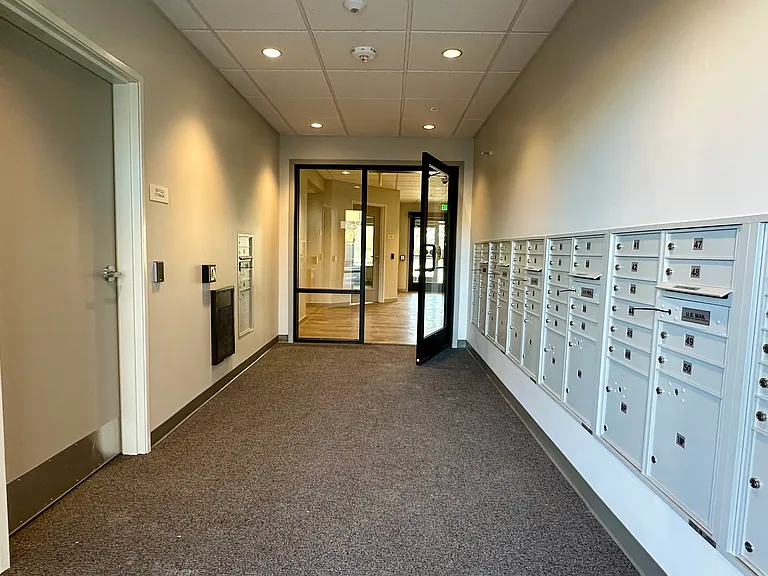 Main entrance vestibule with USPS mailboxes and access to the bike storage room.