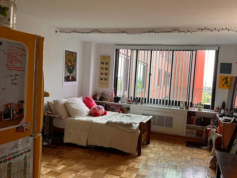 Looking into room as furnished by a past tenant. Photo taken standing at front door with refrigerator on left.